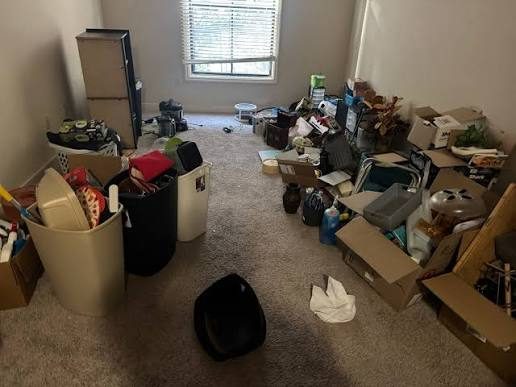 Before: a rental room left full of boxes, bins and belongings after a move-out